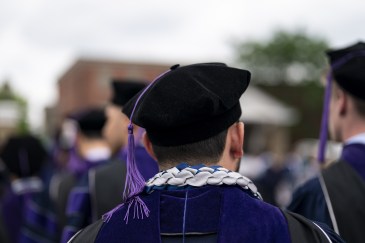 A man with a graduation gown and cap.