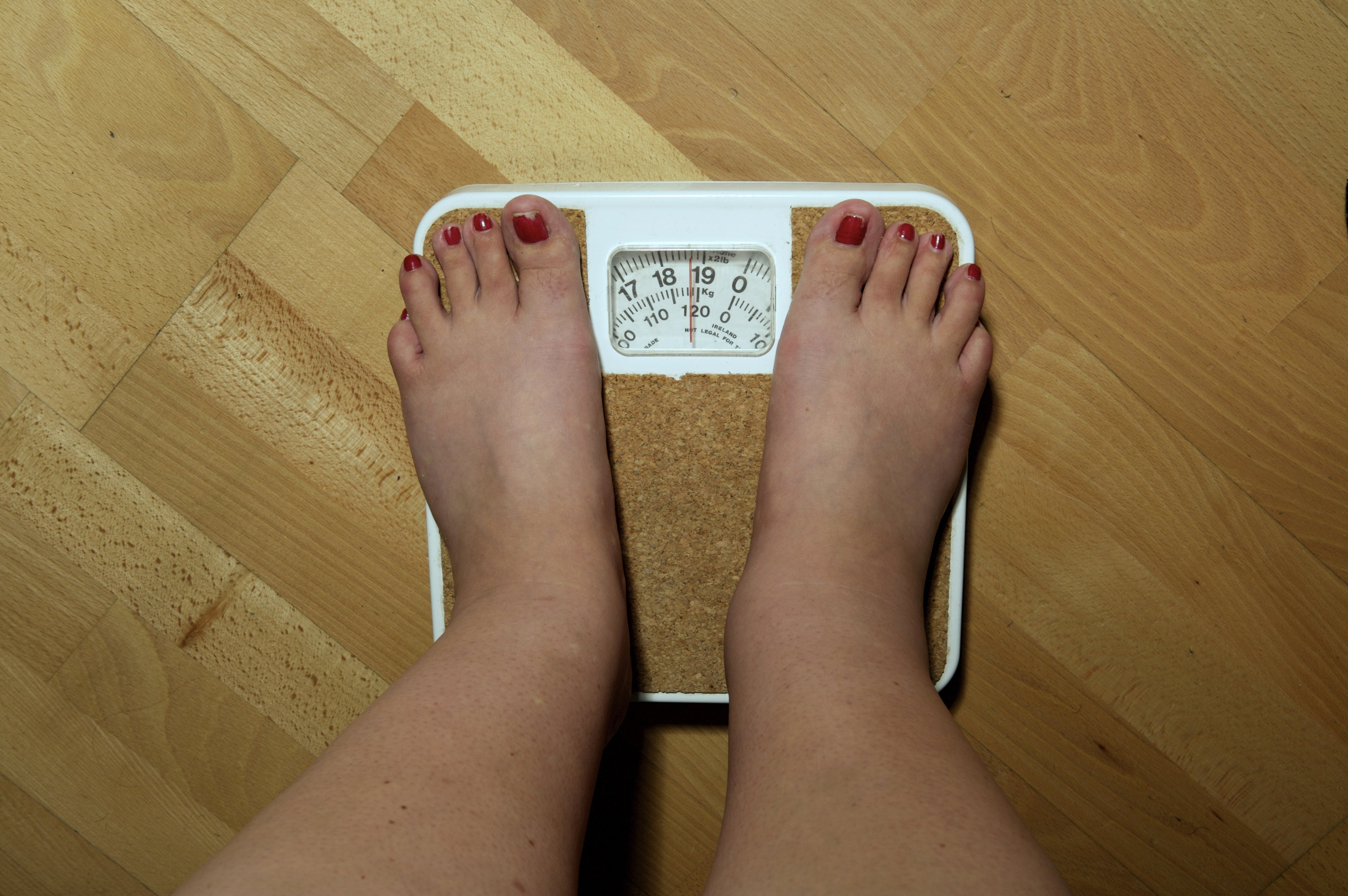 A woman stands on a scale.