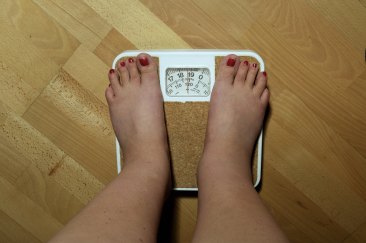 A woman stands on a scale.
