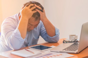 Man looking stressed while sitting at his computer