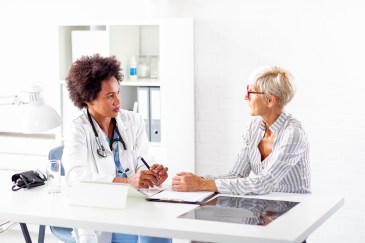 Female doctor speaking with female patient