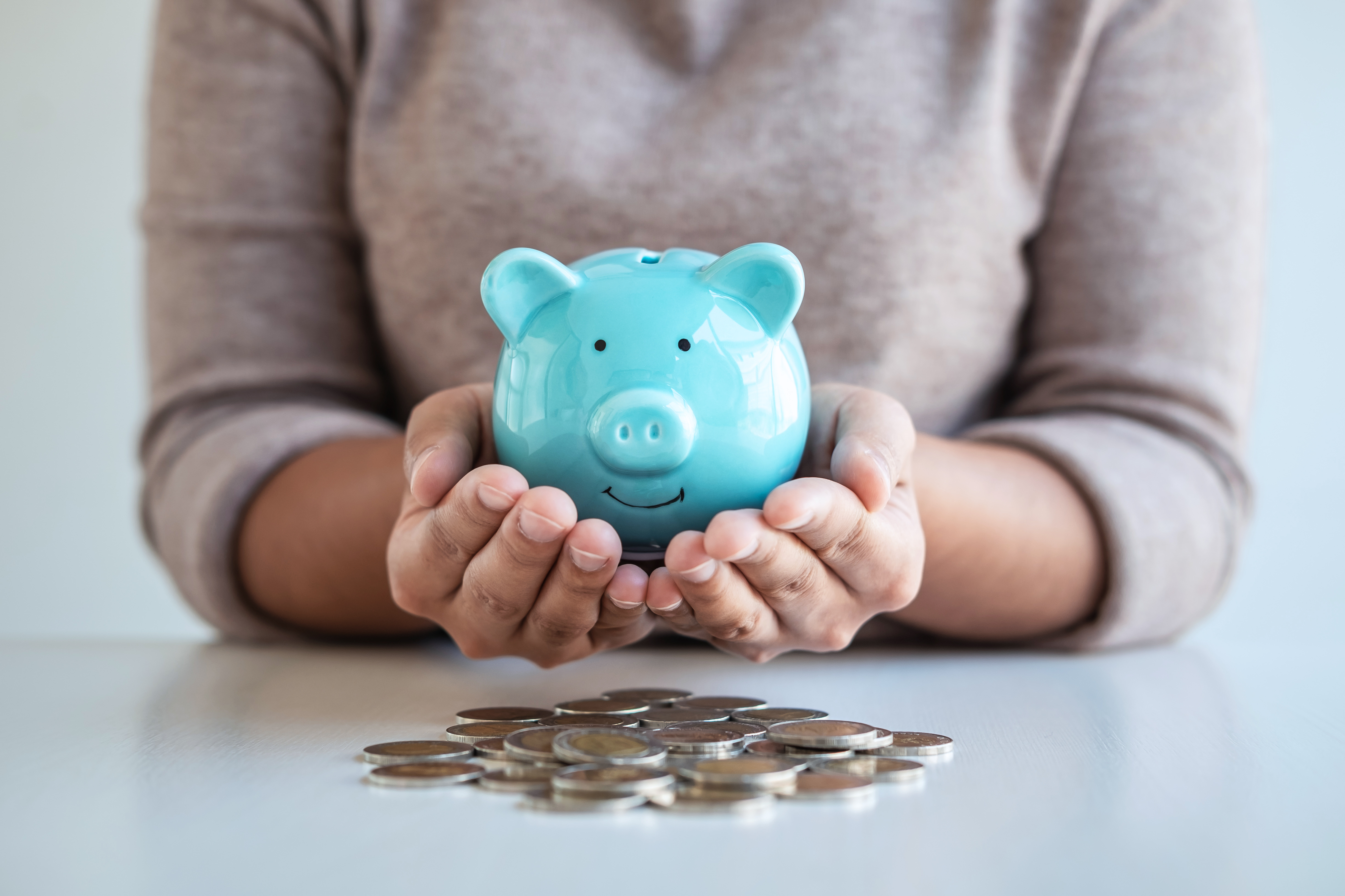 Woman holding a piggybank with coins