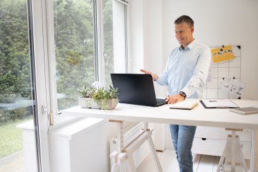 Man working on laptop at standing desk