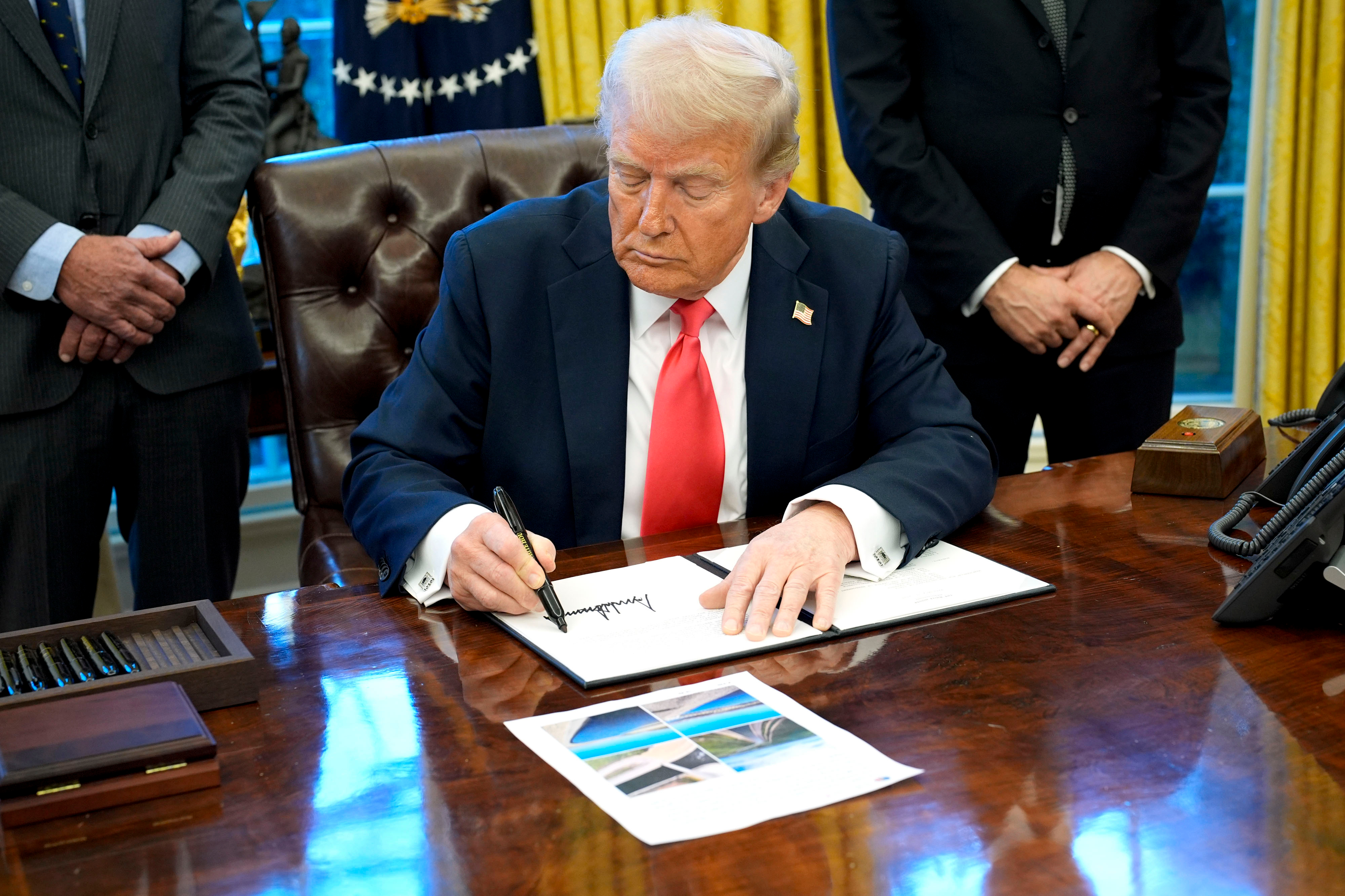 Donald Trump signs an executive order in the Oval Office on Feb. 25.