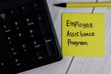 Laptop with a sticky note next to it