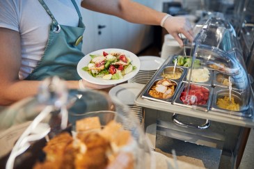 Filling a plate from a lunch buffet at the office