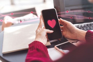 Woman holding a phone with a heart on the screen