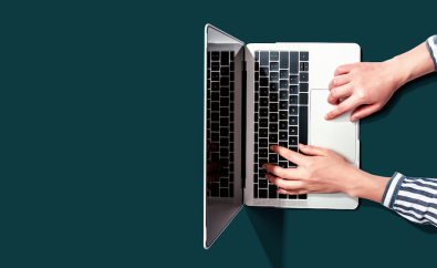 Woman's hands typing on a laptop