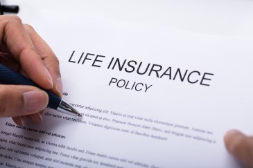 Woman signing a life insurance policy