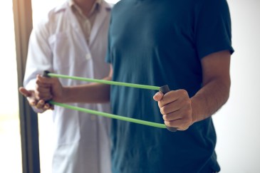 Man stretching a band during physical therapy
