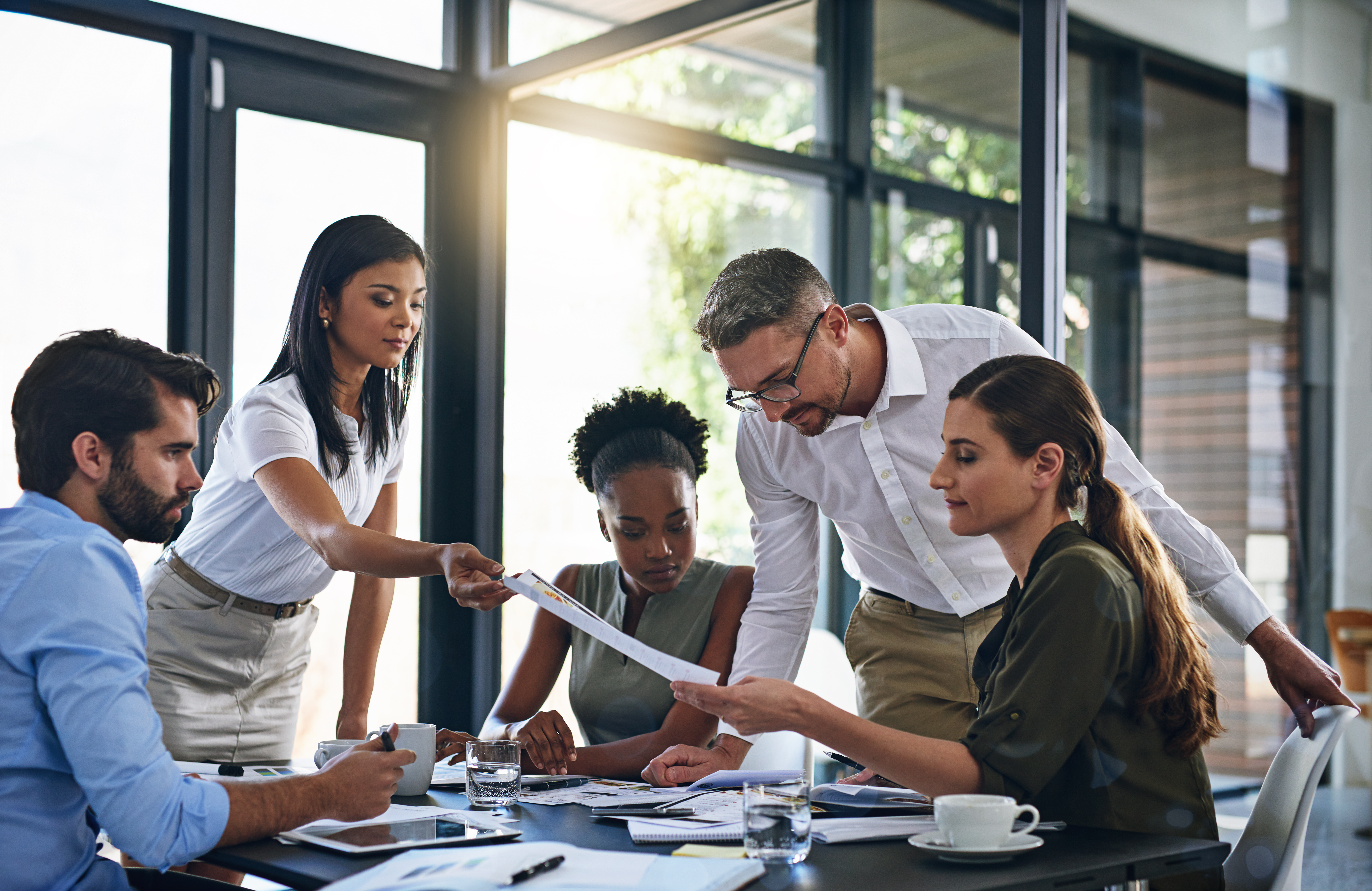 Employees working together around table, sitting, standing