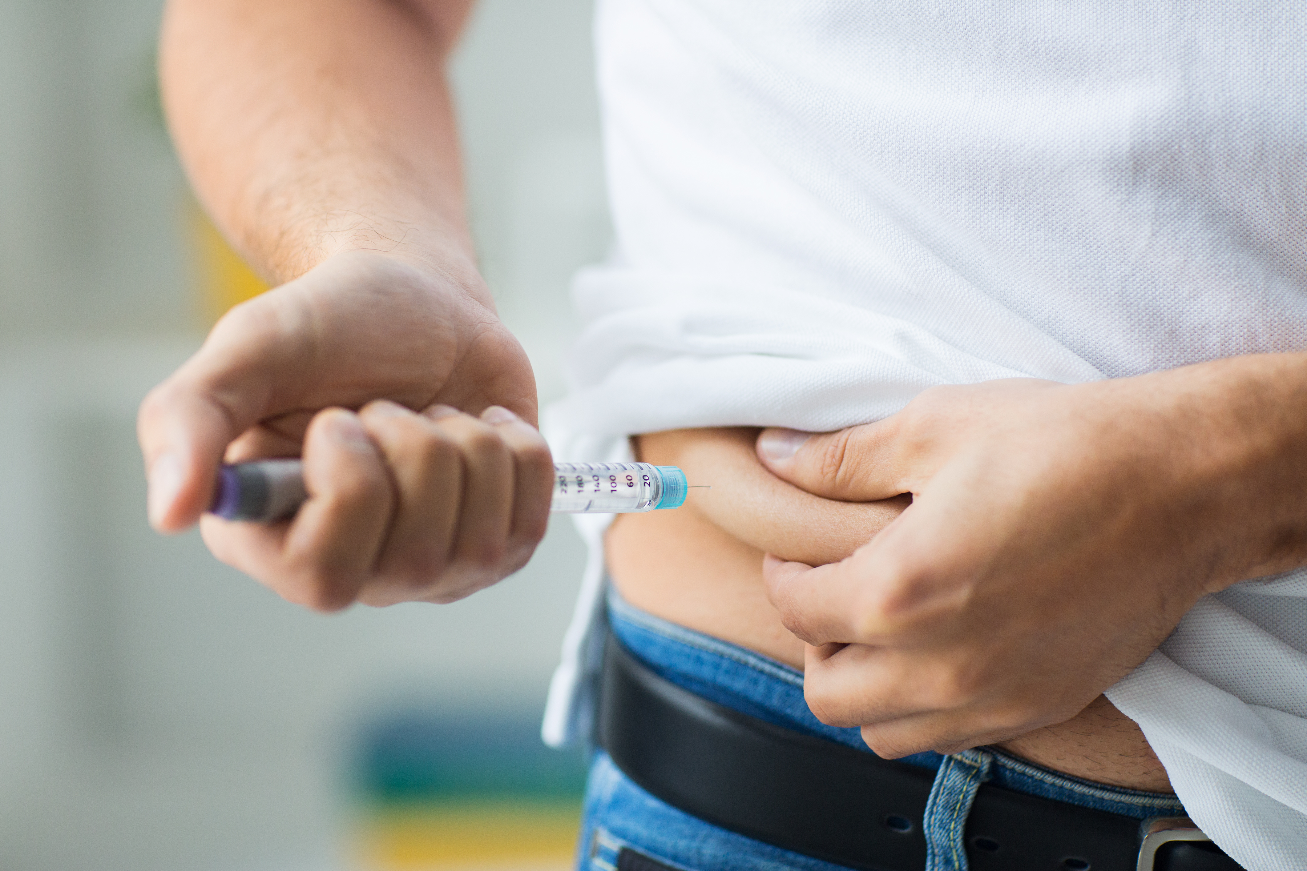 Man injecting insulin with needle