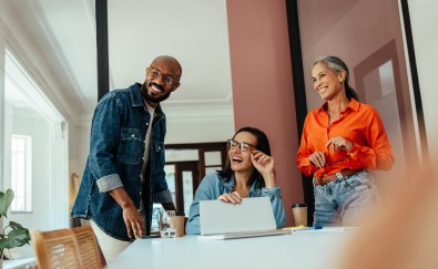 Three people in conference room, smiling
