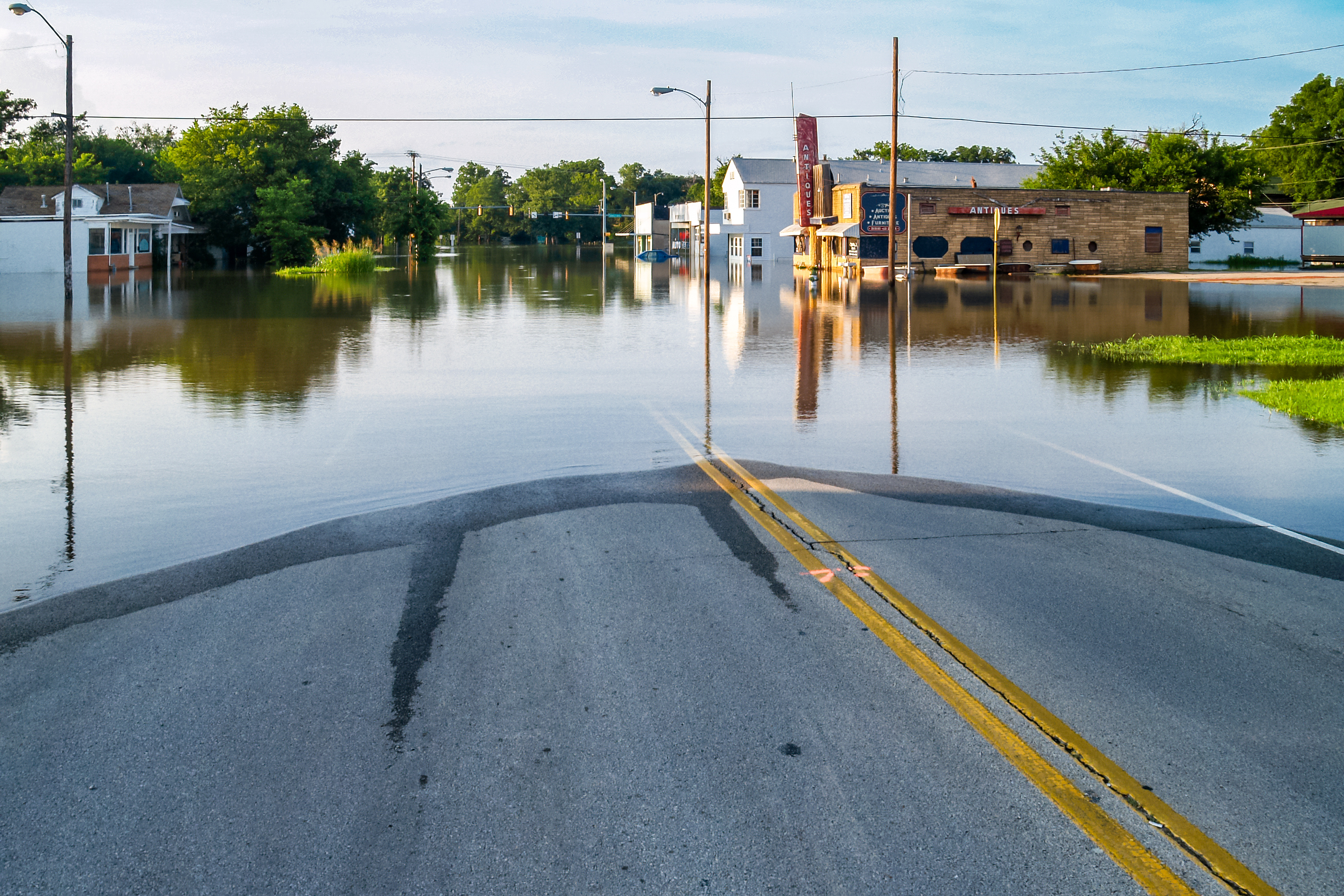 Flooded street between what looks like small businesses.