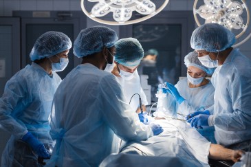Surgeons operating, lights overhead
