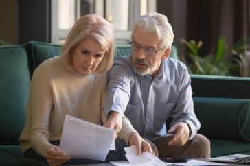 Couple looking over their finances and looking concerned