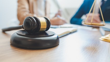 Gavel on a desk with people talking in the background