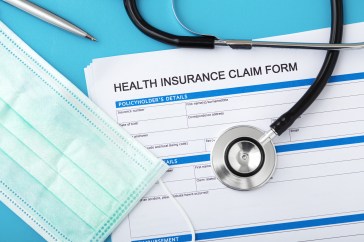 Health insurance paperwork with medical mask