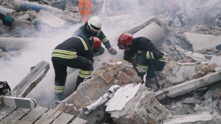 Rescuers searching rubble after earthquake, collapsed building