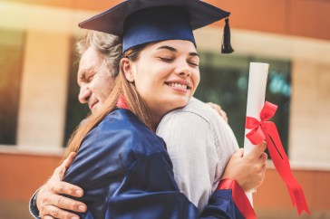 Female graduate hugging dad