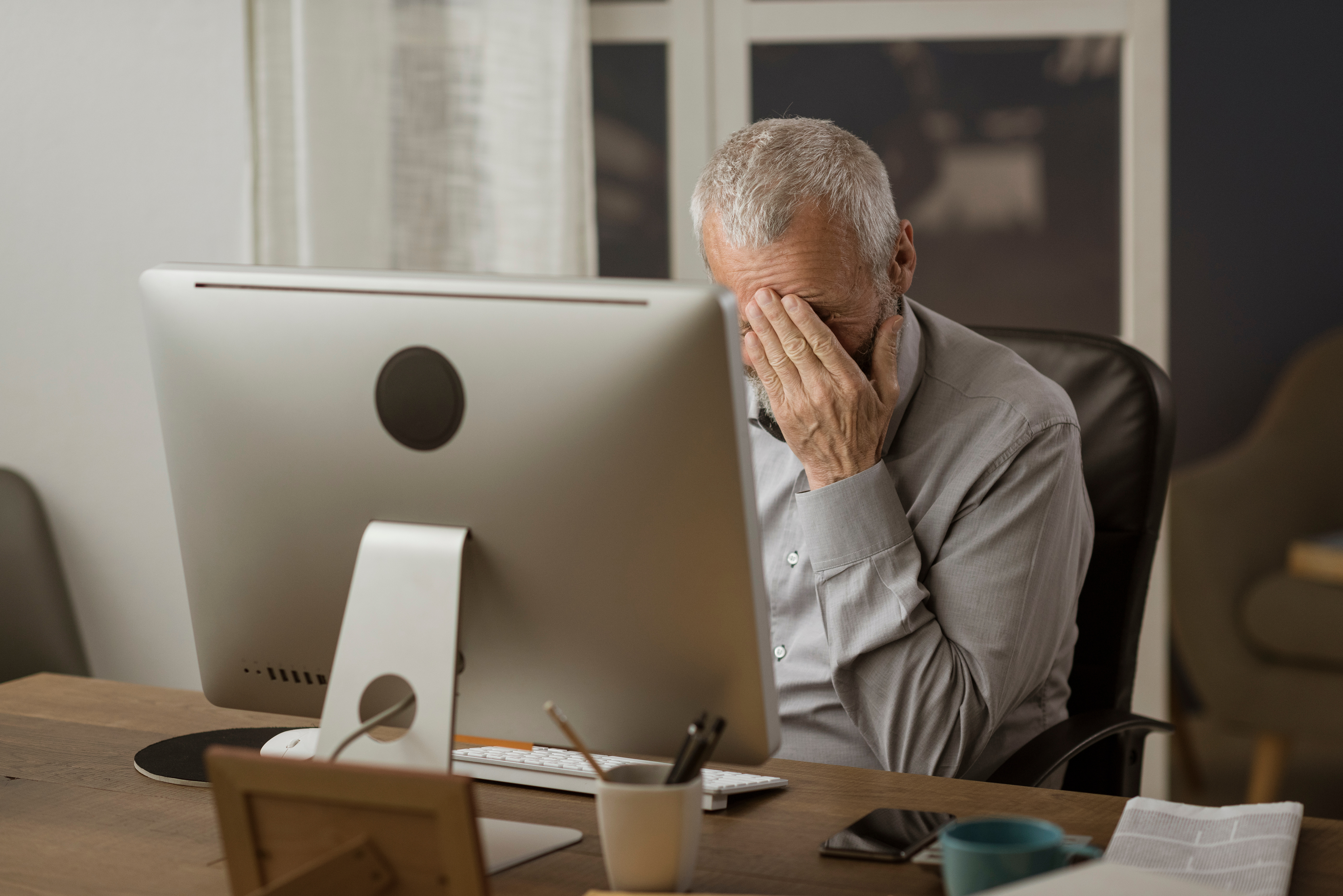 Man looking stressed in front of his computer