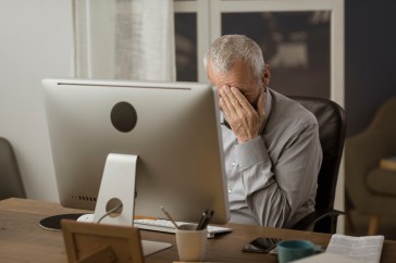 Man looking stressed in front of his computer