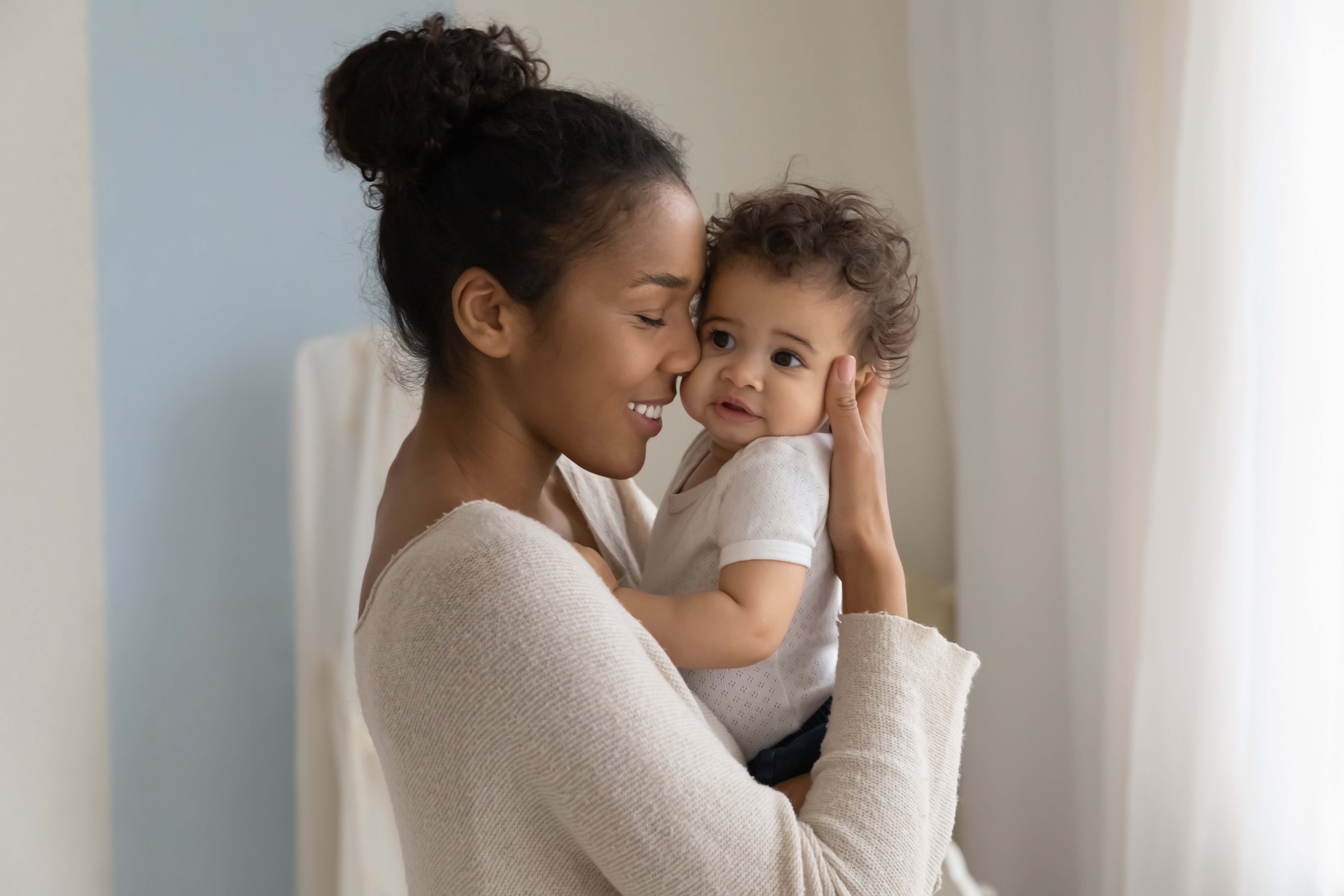 Mom holding young baby, smiling