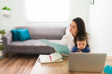 Mom reading with her child while doing work