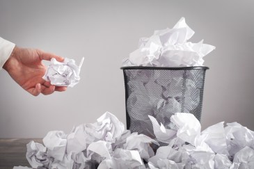 Man throwing paper into a waste basket