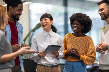 Group of employees standing, laughing