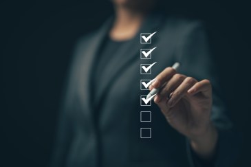 Woman in suit checking off boxes