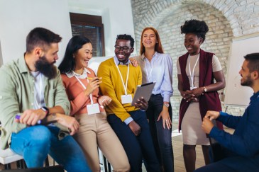 Group of employees, happy, leaning on desk together