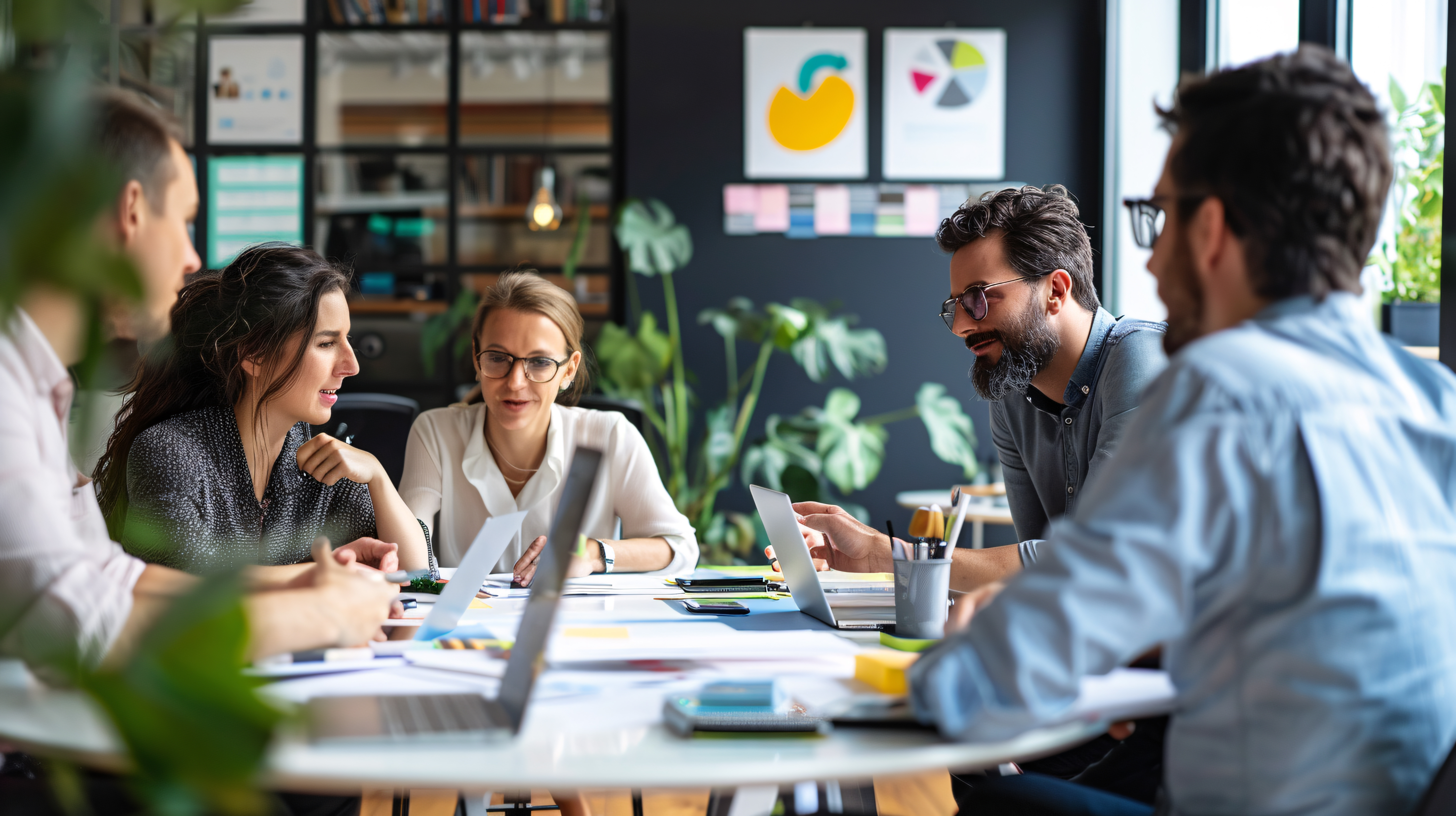 Group of employees sitting around table working, problem solving