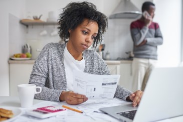Woman looking at bills and computer