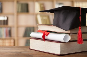 Stack of books with college cap