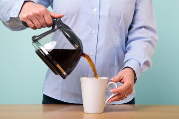 Man pouring coffee into mug