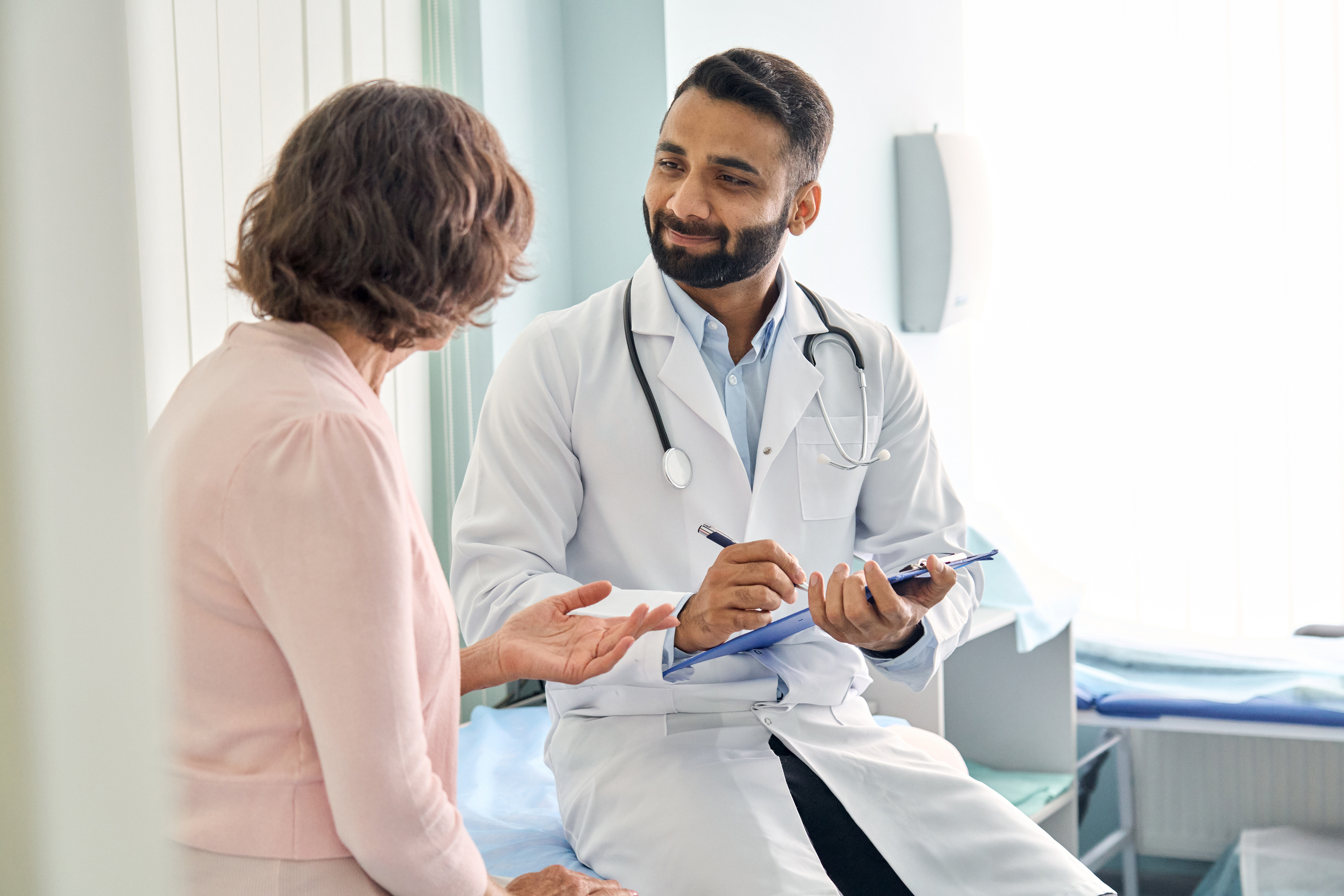 Male physician speaking with female patient