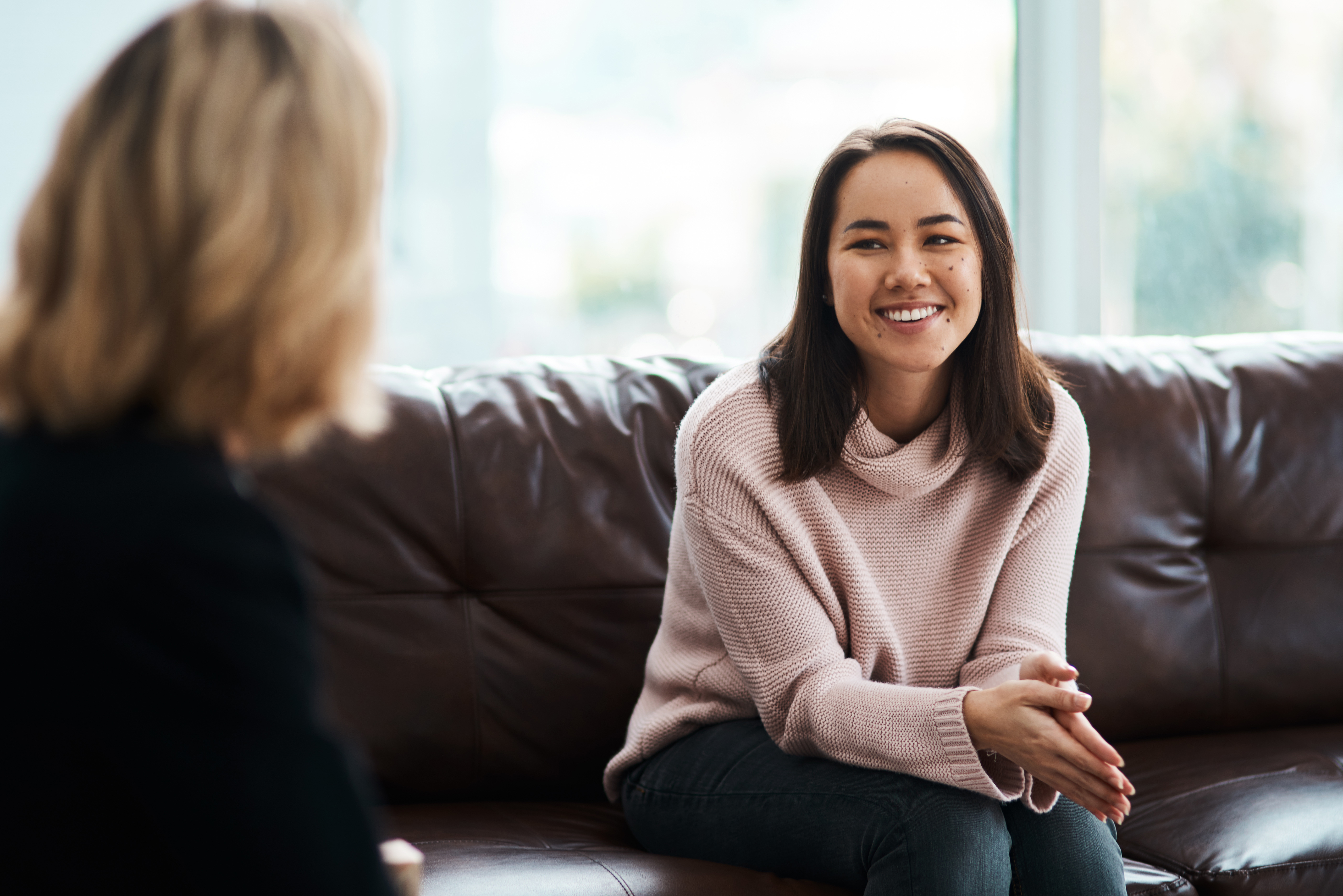Woman sitting on sofa, speaking with therapist