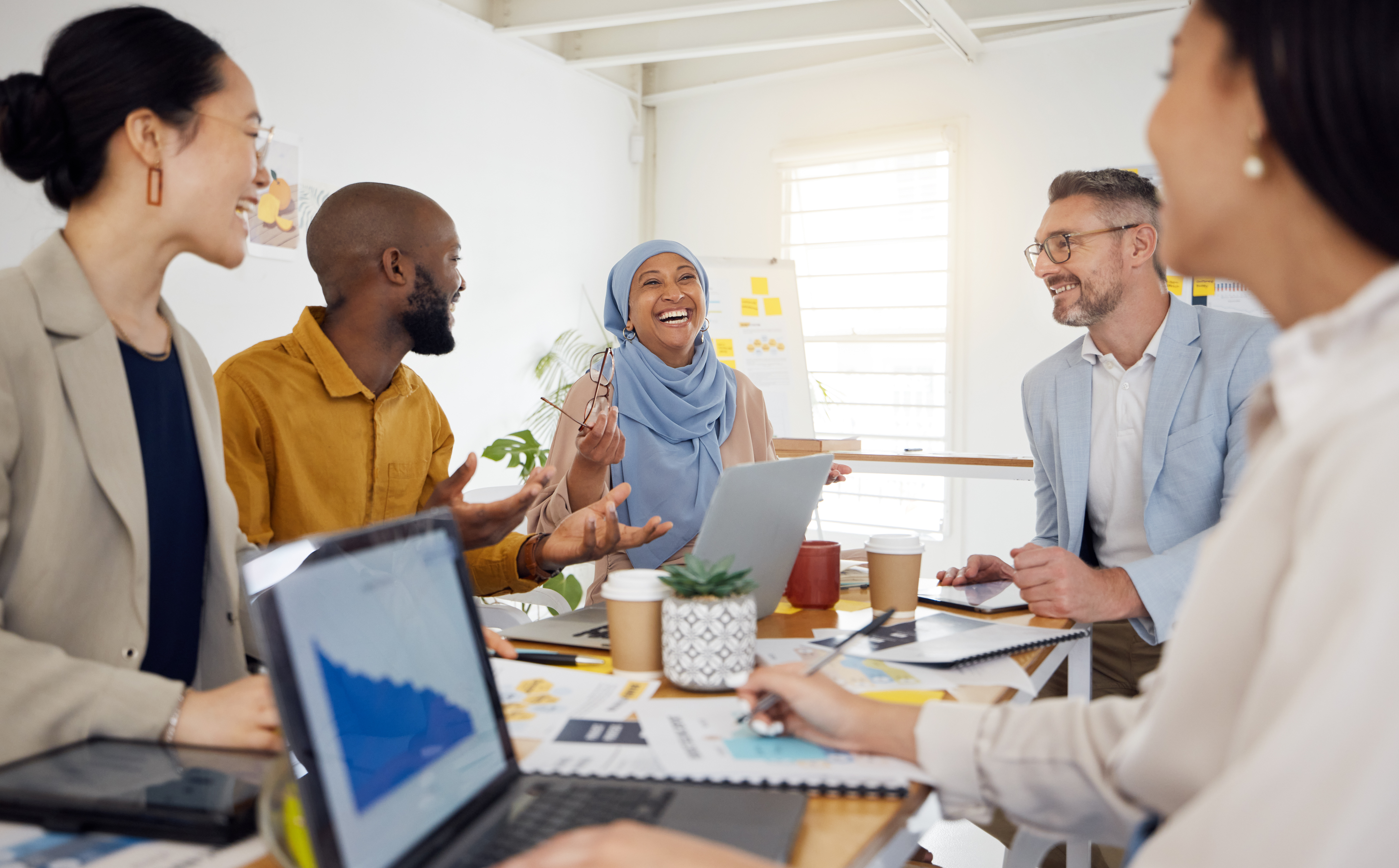 Group of diverse employees sitting at table smiling
