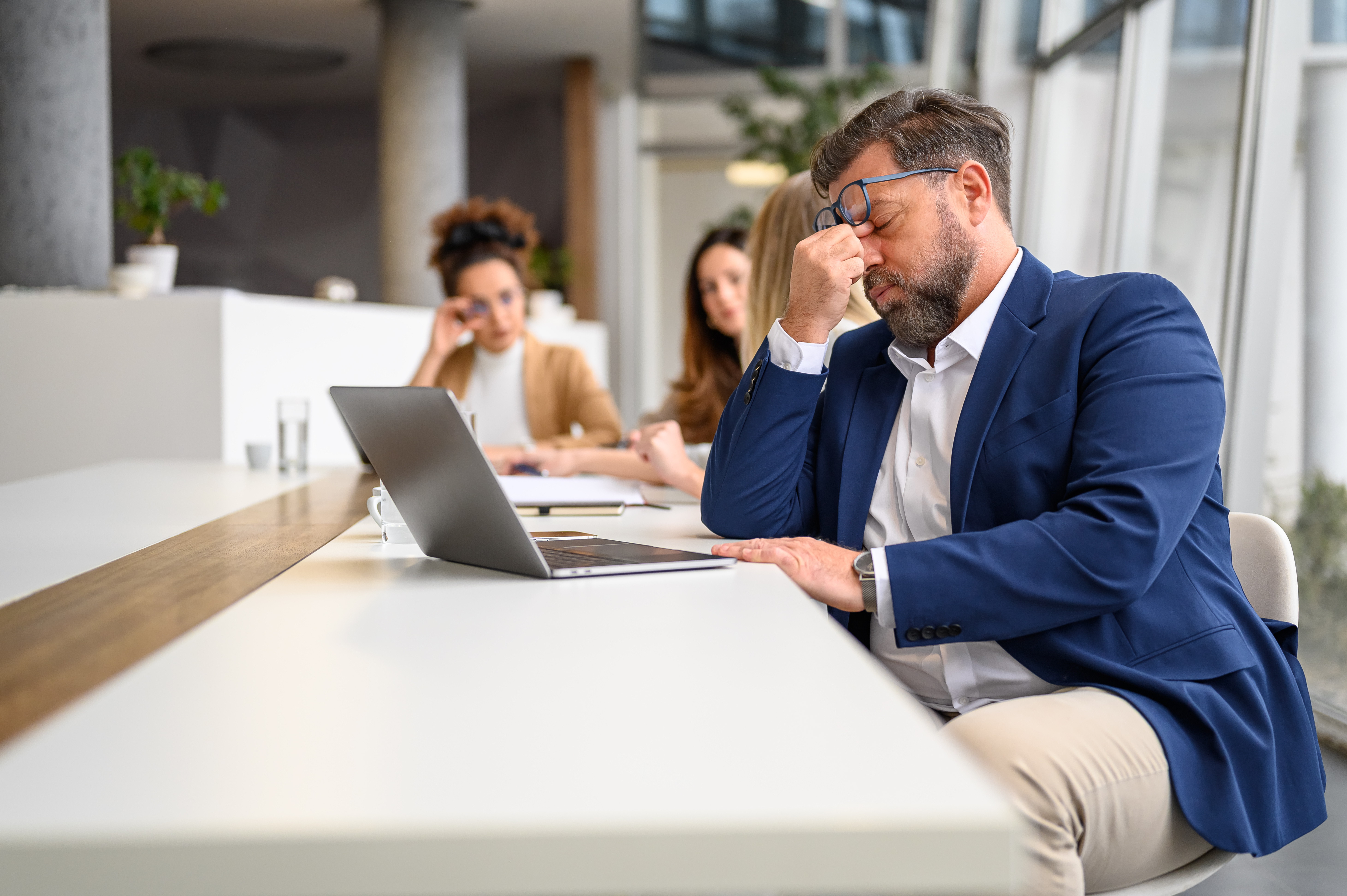 Stressed employees sitting at conference table