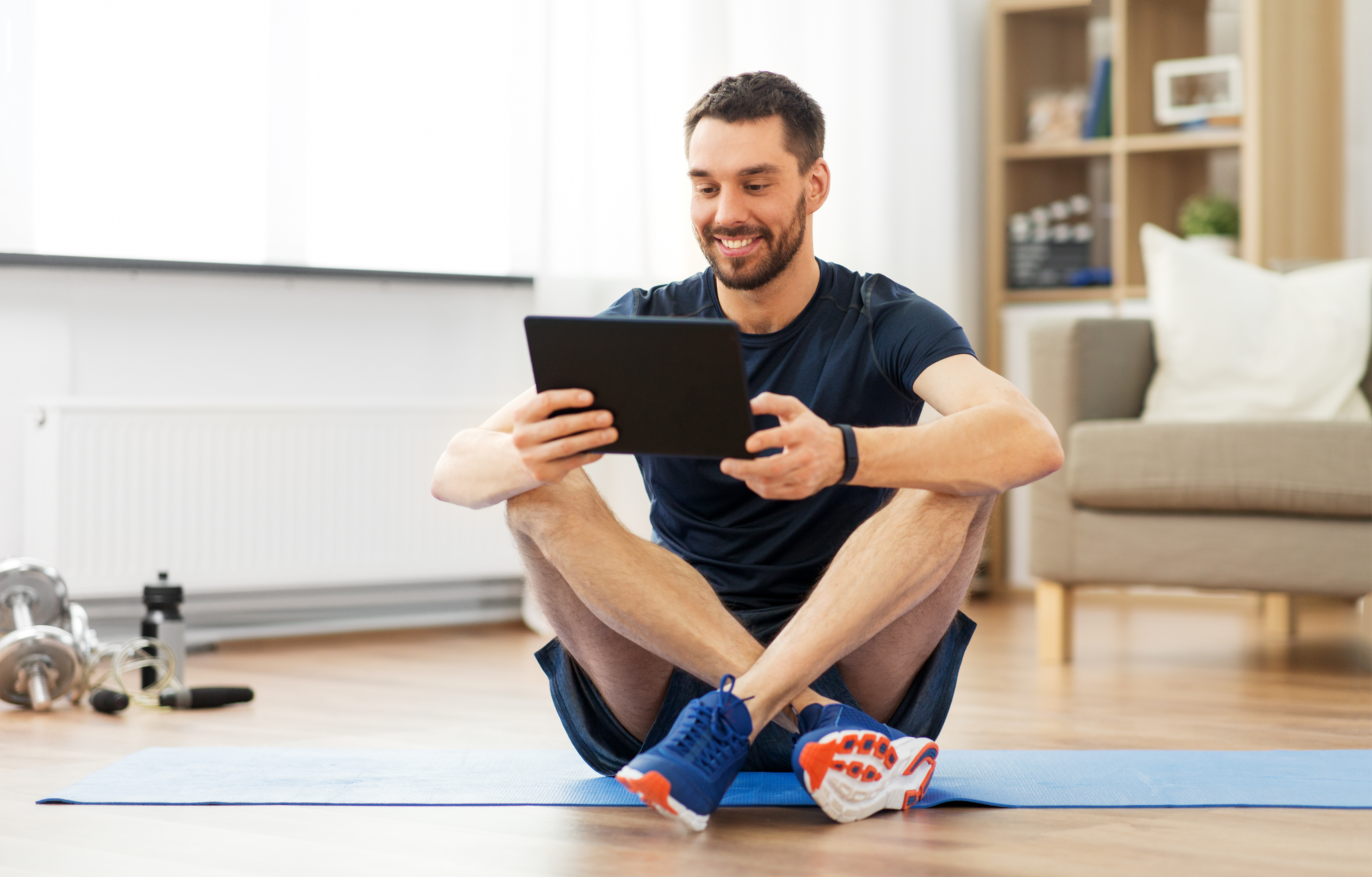 Man exercising, holding iPad