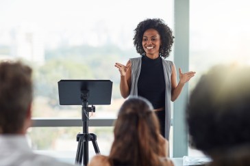 Woman speaking to room of professionals