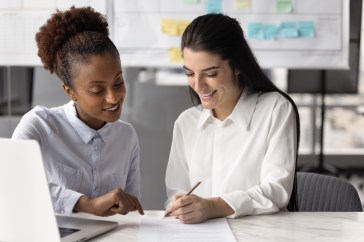 Women talking and looking at paper