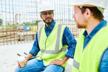 Two men in construction gear talking on job site