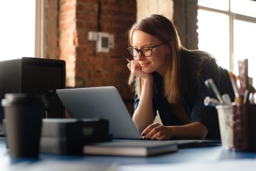 Woman working on laptop, smiling