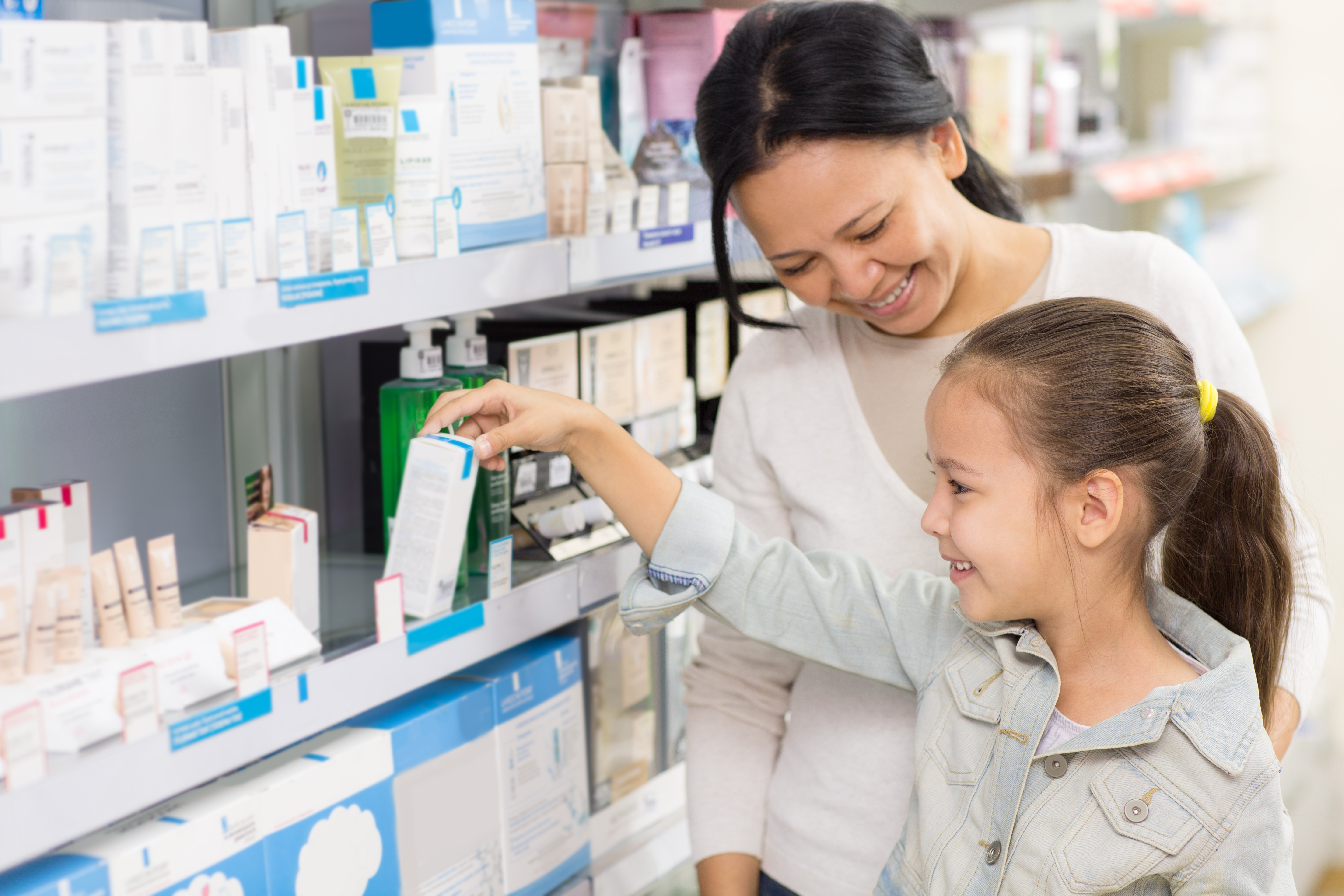 Mom and daughter picking out item at pharmacy