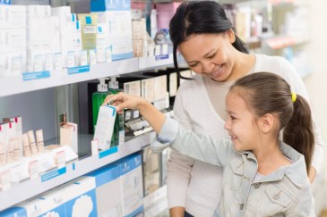Mom and daughter picking out item at pharmacy