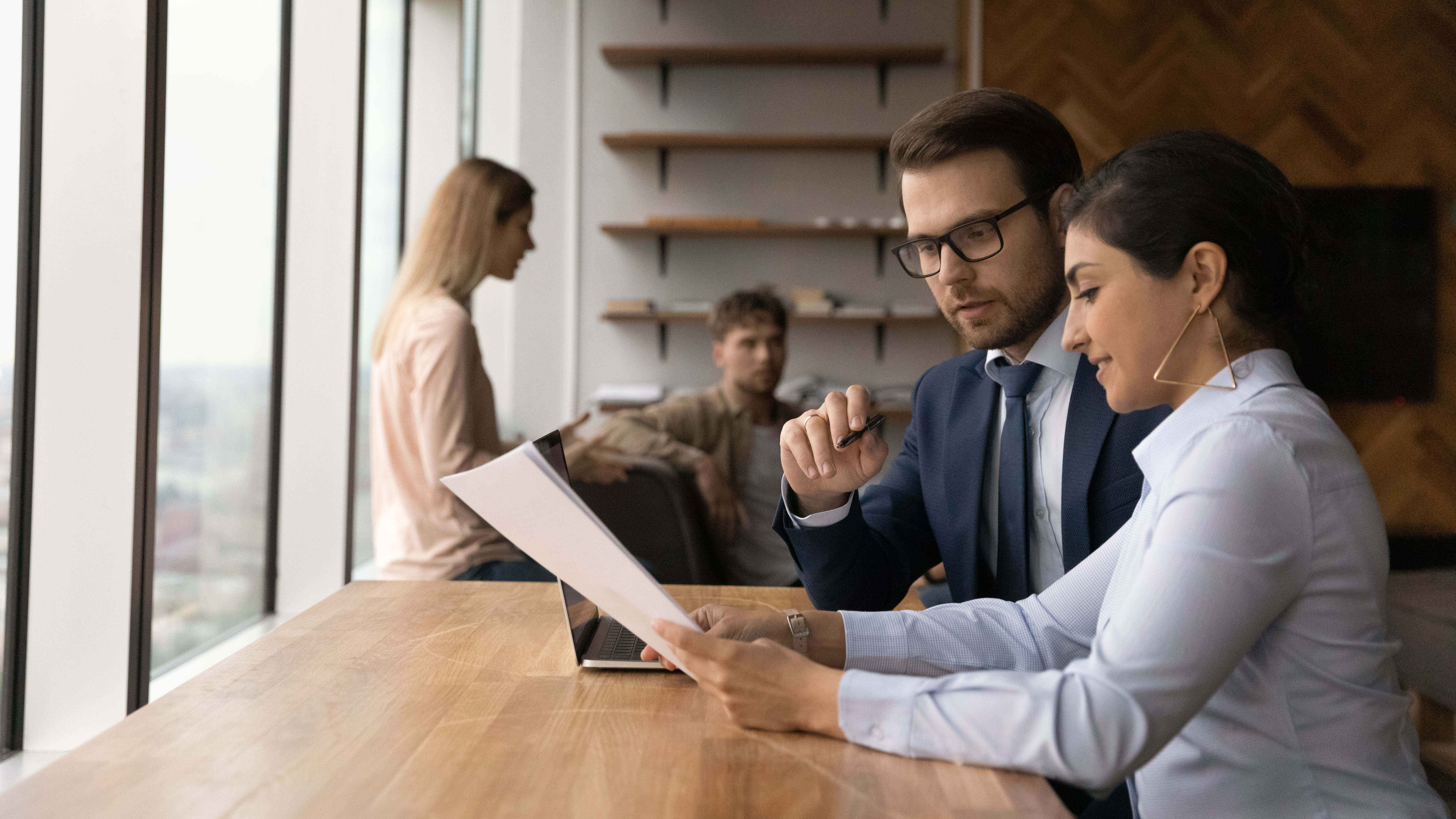 Two employees looking over paperwork together
