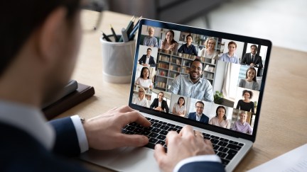 Businessman talking to team of colleagues on laptop online video conference