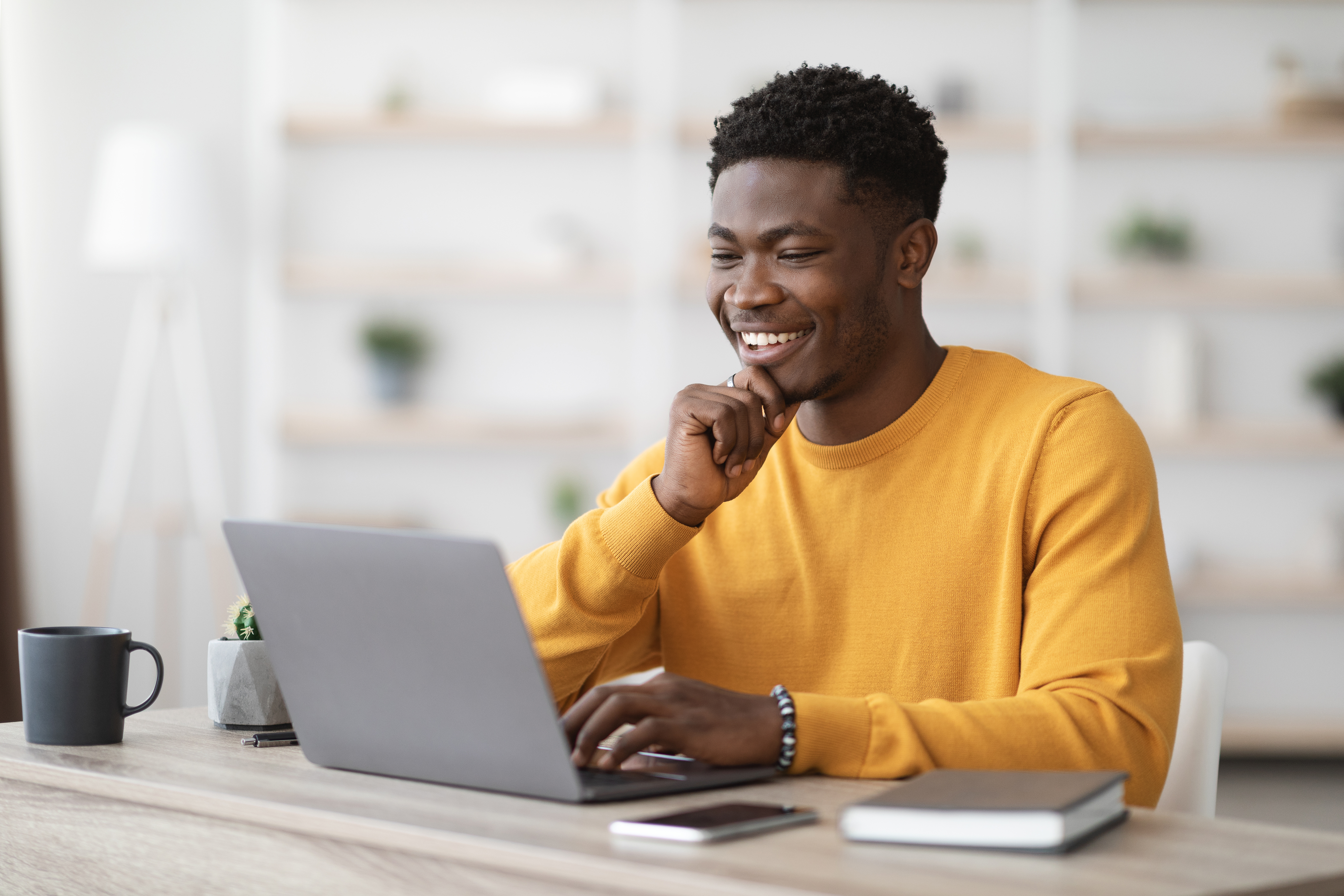 Man working on laptop, smiling